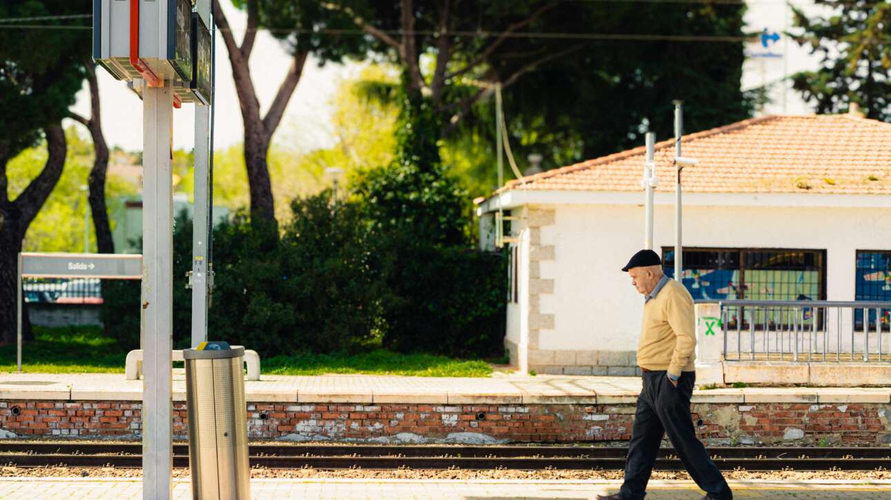 Senior man walking along a railway platform in Madrid, Spain, showcasing urban daily life.